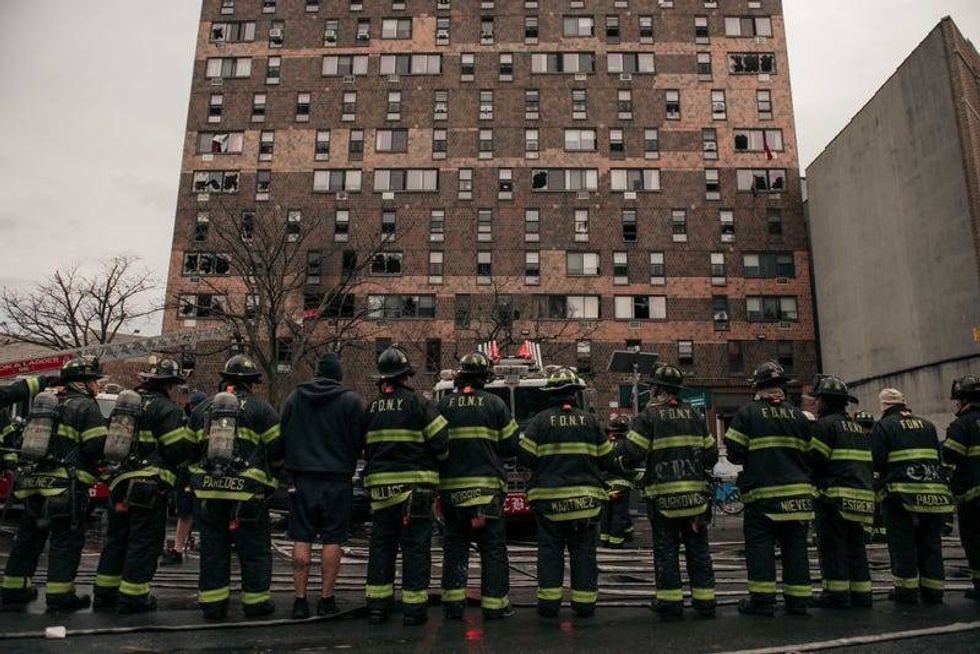 Emergency first responders remain at the scene after an intense fire at a 19-story residential building that erupted on Jan. 9, 2022