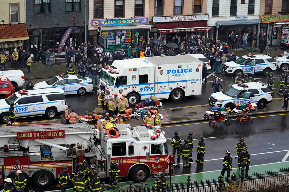 Emergency personnel gather at the entrance to a subway stop in the Brooklyn borough of New York, Tuesday, April 12, 2022