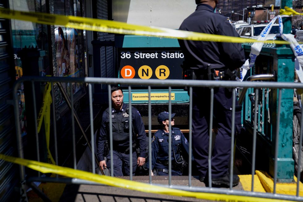 Emergency personnel gather at the entrance to a subway stop in the Brooklyn borough of New York, Tuesday, April 12, 2022