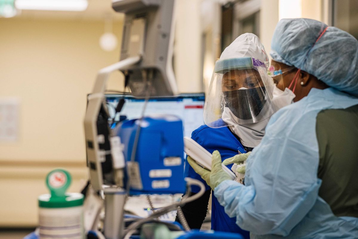 Emergency Room nurses speak to each other inside a Houston hospital.