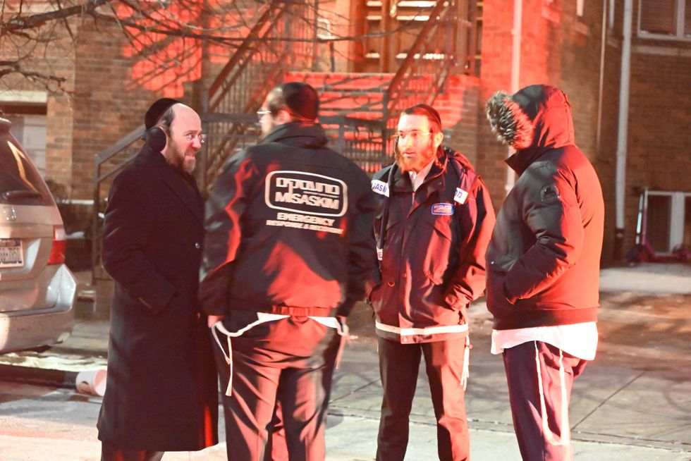 Emergency service workers speak at the scene of the fatal double stabbing on Jan. 20, 2024