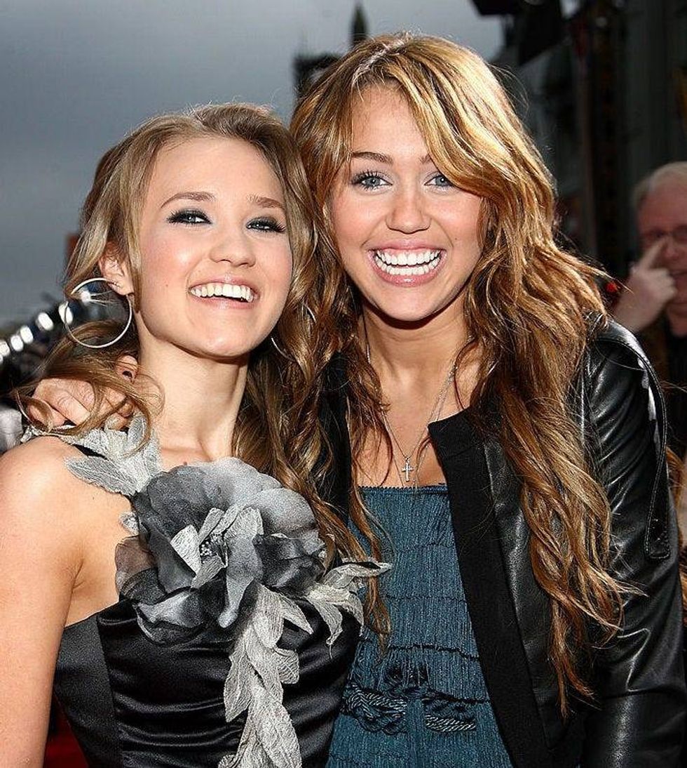 Emily Osment and actress/singer Miley Cyrus arrive at the premiere of Walt Disney Picture