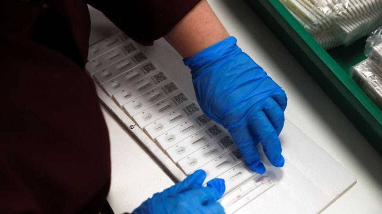 Employees assemble PCP coronavirus disease (COVID-19) test kits during a visit by Prime Minister Boris Johnson to SureScreen Diagnostics on February 7, 2021 in Derby, England