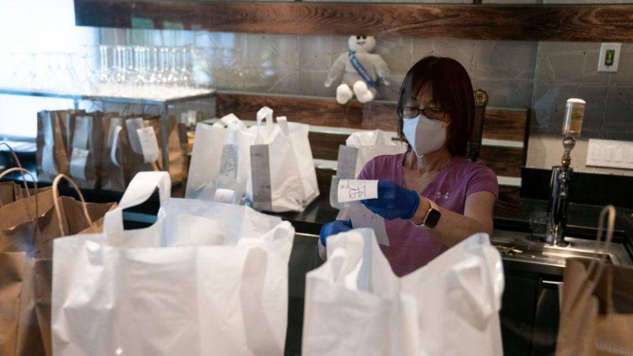 Employees of the Sushi Taro sushi restaurant assist with carry out orders on May 2, 2020 in Washington, DC.