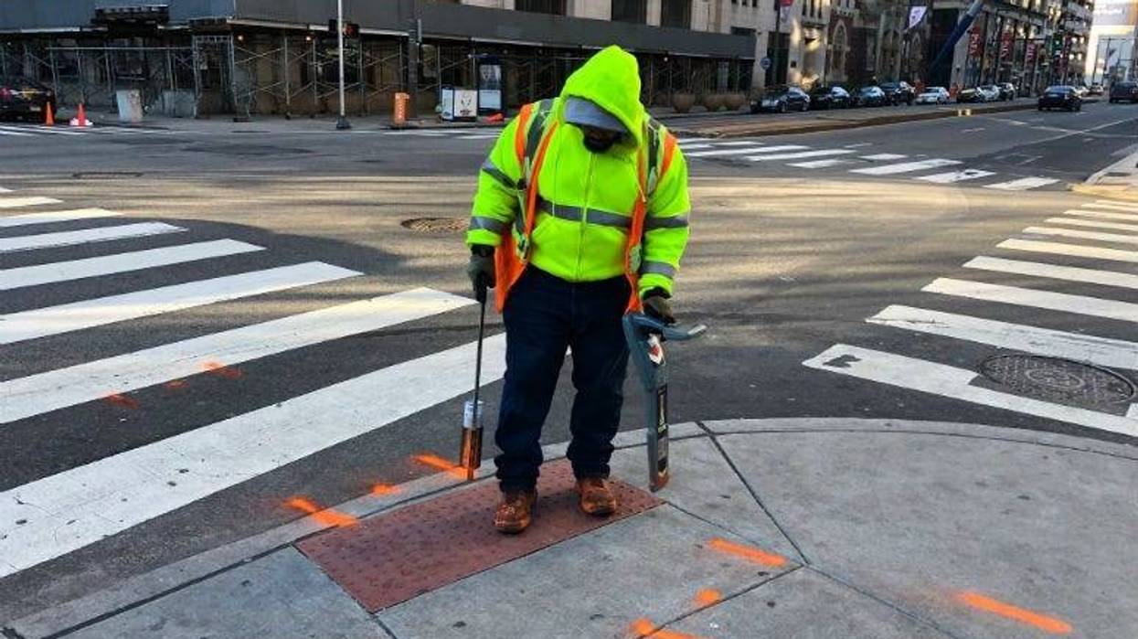 Errol Ray outside spraying paint in Center City on a frigid Monday afternoon.