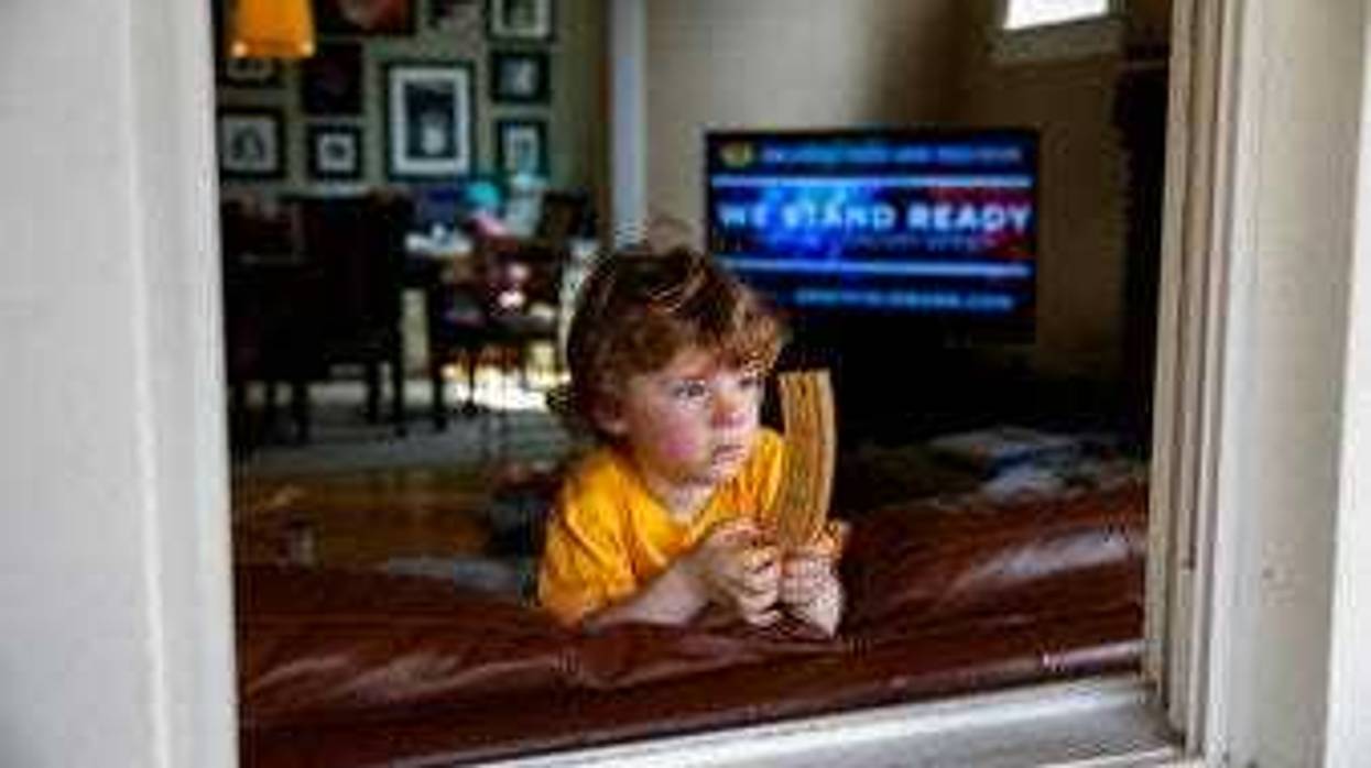 Ethan McIver, 4, son of U.S. Army Field Band member Sgt. Major Robert McIver, Jr., holds part of his toy train set as he looks out the window of his home in Catonsville, Md., Thursday, March 26, 2020. (AP Photo/Carolyn Kaster)