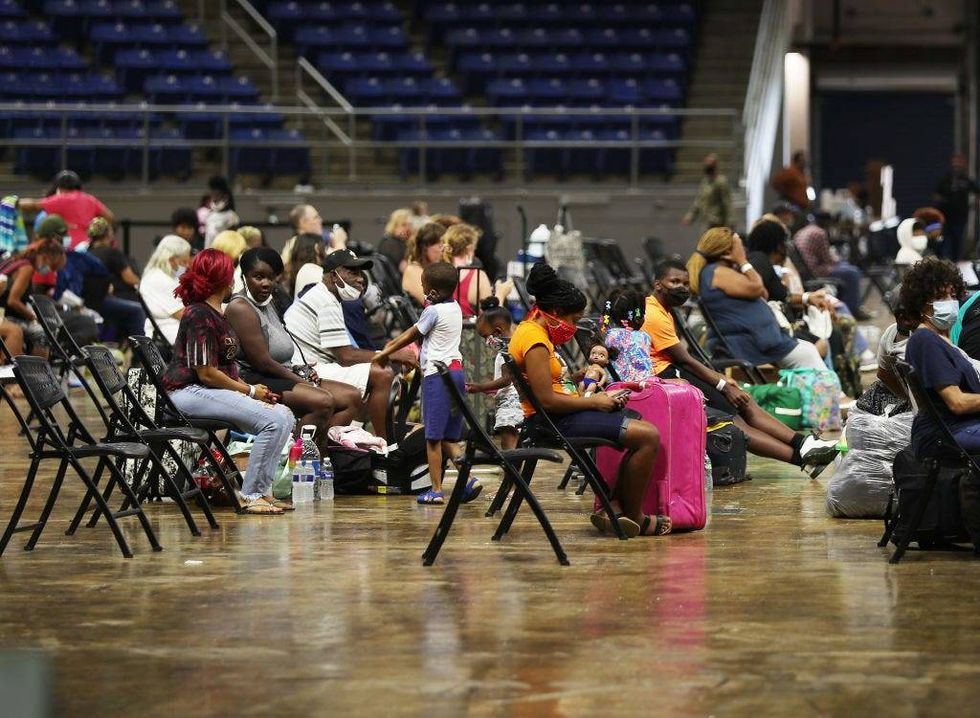 Evacuees wait to board buses as they are evacuated by local and state government officials before the possible arrival of Hurricane Laura in Lake Charles, Louisiana