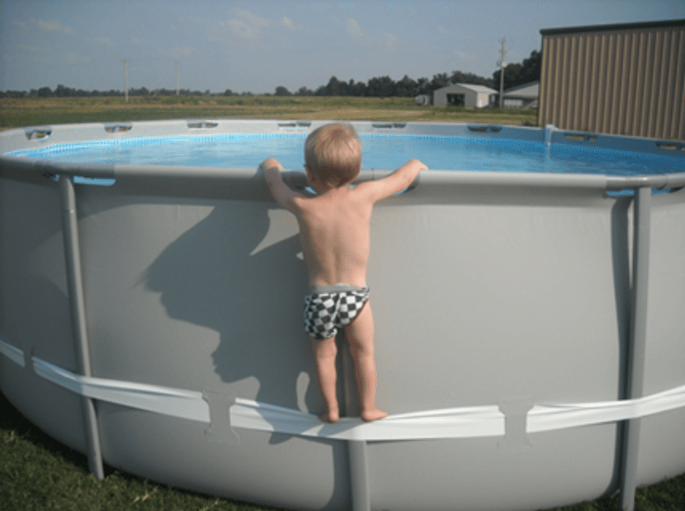 Example of child using the compression strap to stand on above-ground pool, illustrating the hazard involved.