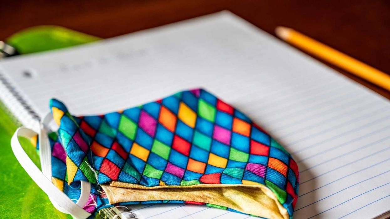 Face mask resting on top of back to school supplies
