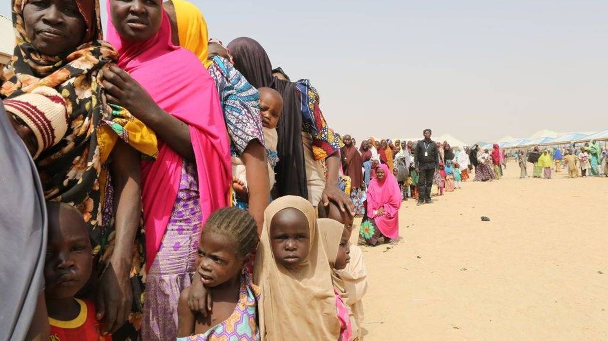 Families displaced by the Boko Haram insurgency line up for food being distributed by International Medical Corps in northeast Nigeria's Borno state on January 29, 2018 in Maiduguri, Nigeria.