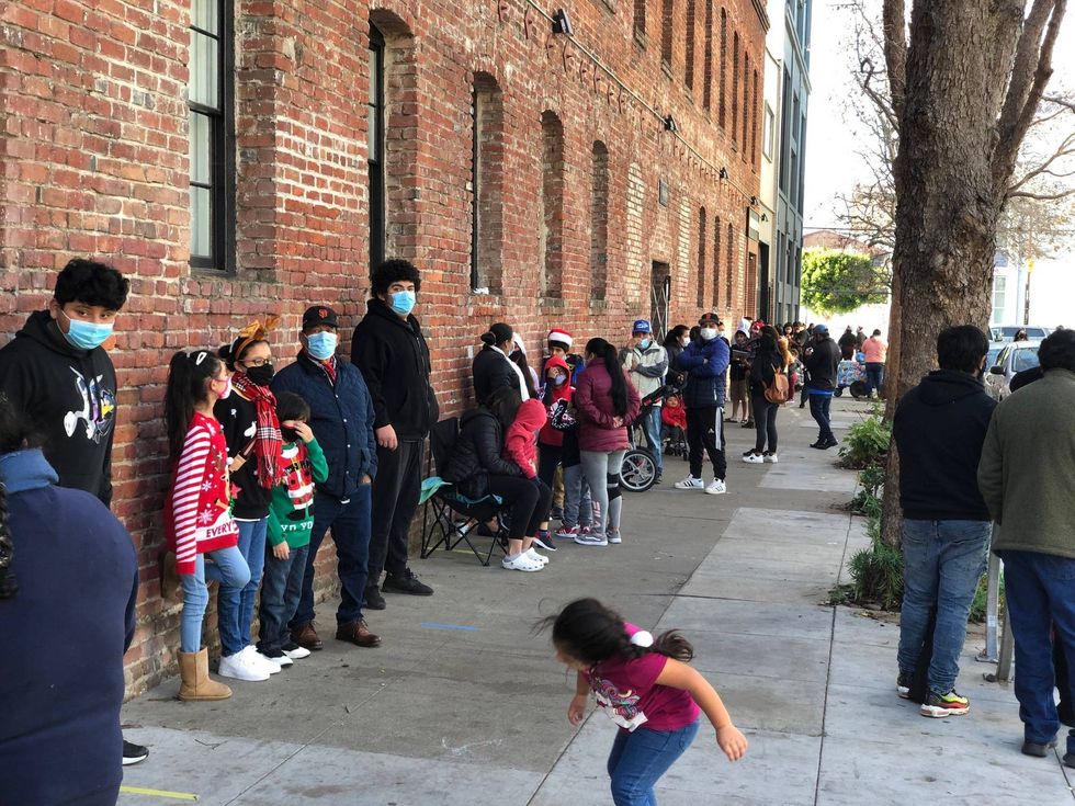 Families line up at the Mission Food Hub to pick up their free toys.