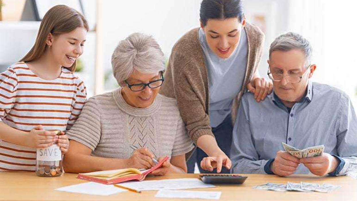 Family are sitting at a desk with a paper receipt and calculating expenses, managing budget.
