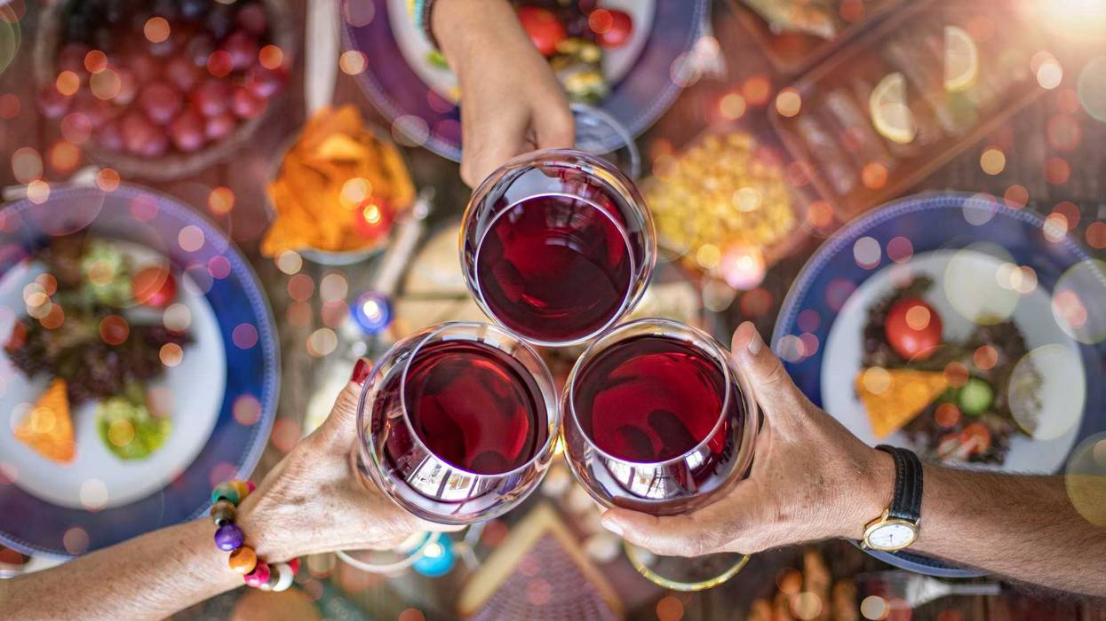 Family dinner for a celebration with red wine and cheers