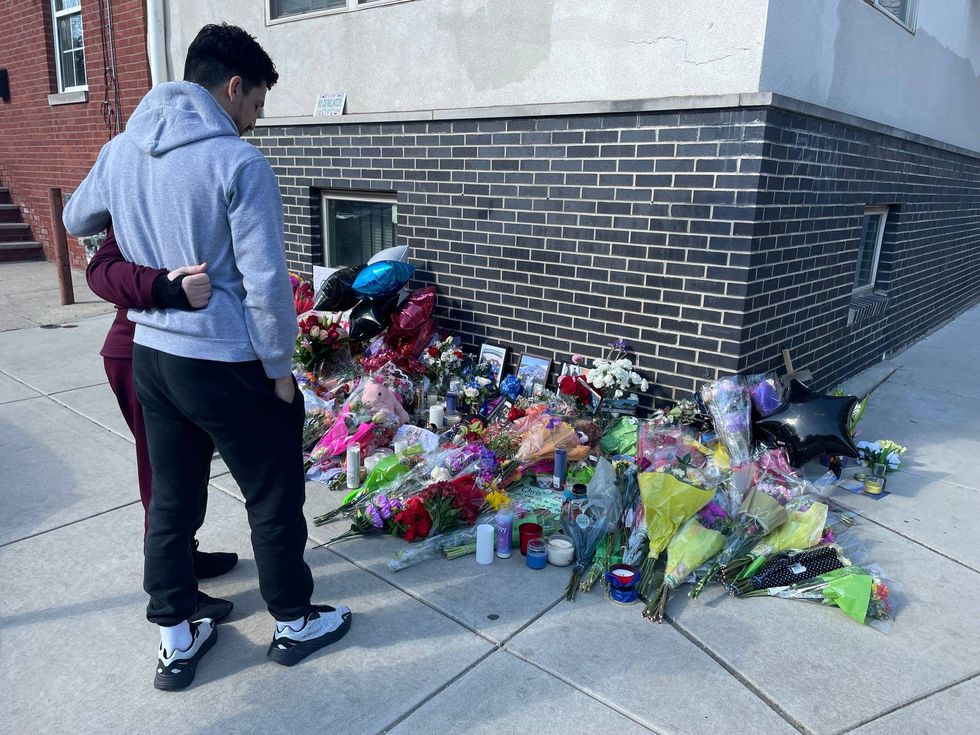 Family members gather at the corner of Montgomery Avenue and Bouvier Street where a makeshift memorial has been created for Temple University police officer Christopher Fitzgerald, who was shot and killed Saturday night.