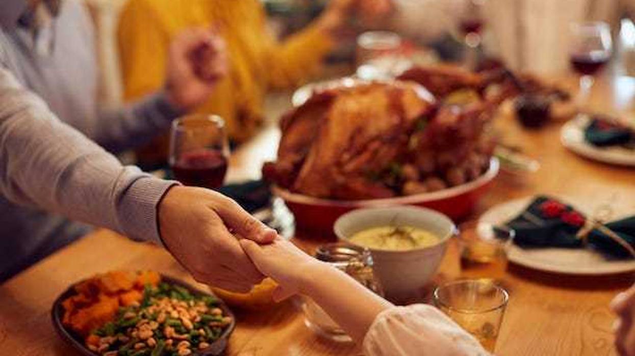 Family praying before Thanksgiving meal