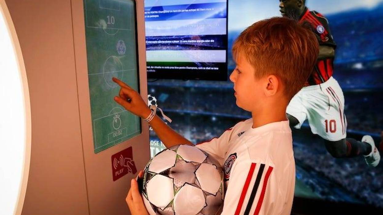 Fan plays games in the UEFA Champions League Trophy Tour Truck at Atheneum Square during the UEFA Champions League Trophy Tours