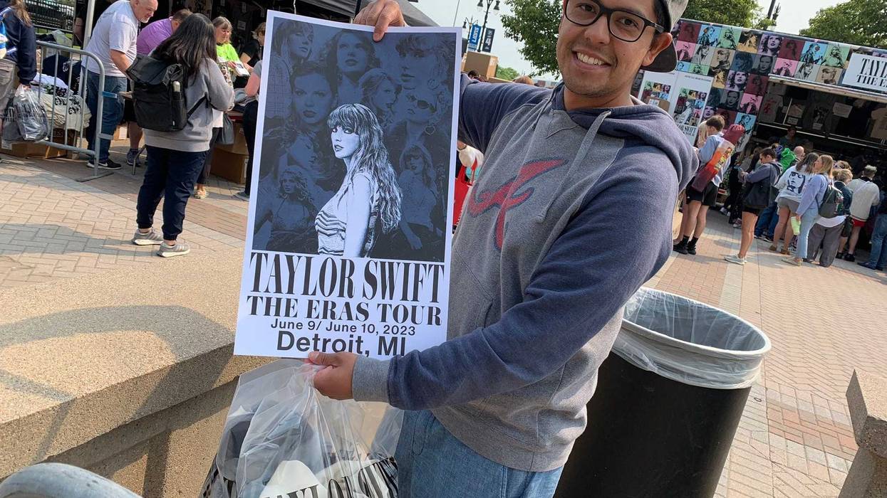 Fan poses with Taylor Swift poster outside Ford Field