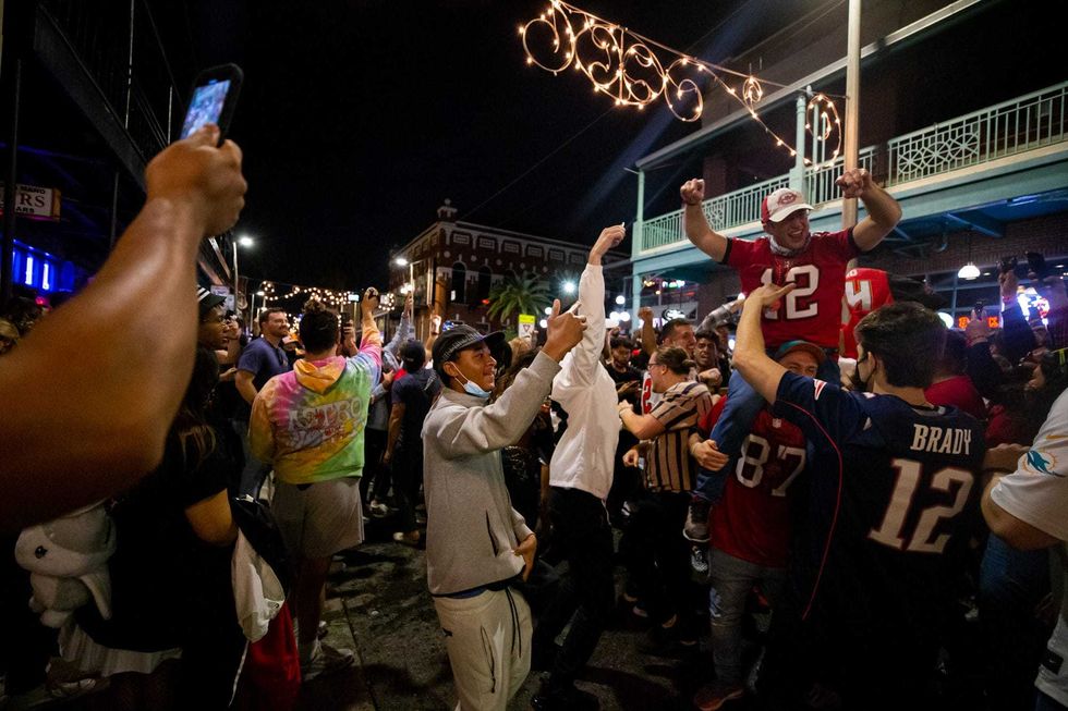 Fans celebrate in the streets of Ybor City in Tampa, FL after the Tampa Bay Buccaneers beat the Kansas City Chiefs in Super Bowl LV