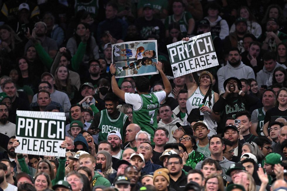 Fans hold up signs for Payton Pritchard #11 of the Boston Celtics during the second half of a game against the Milwaukee Bucks at the TD Garden on October 28, 2024 in Boston, Massachusetts.