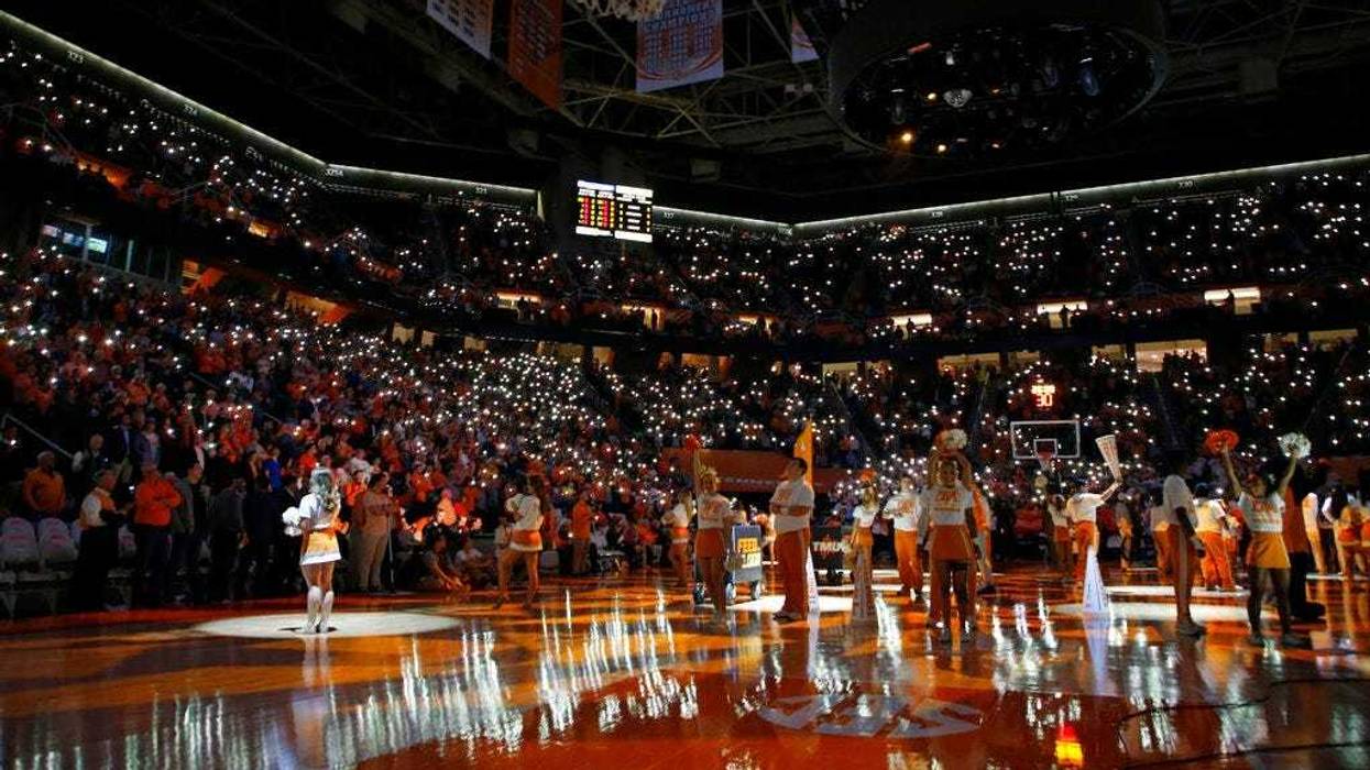 fans hold up their cell phones with the flashlight on as music plays before an NCAA college basketball game between Tennessee and Vanderbilt in Knoxville, Tenn.