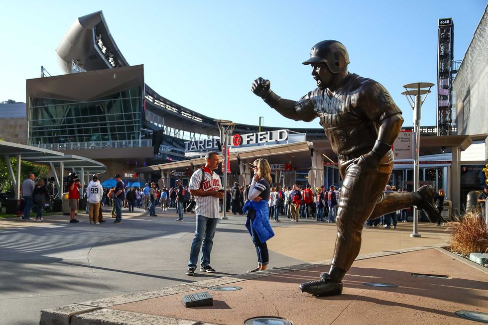 Fans stand next to a Kirby Puckett statue at Target Field, near where Joe Mauer will take his bronzed place in Twins history.