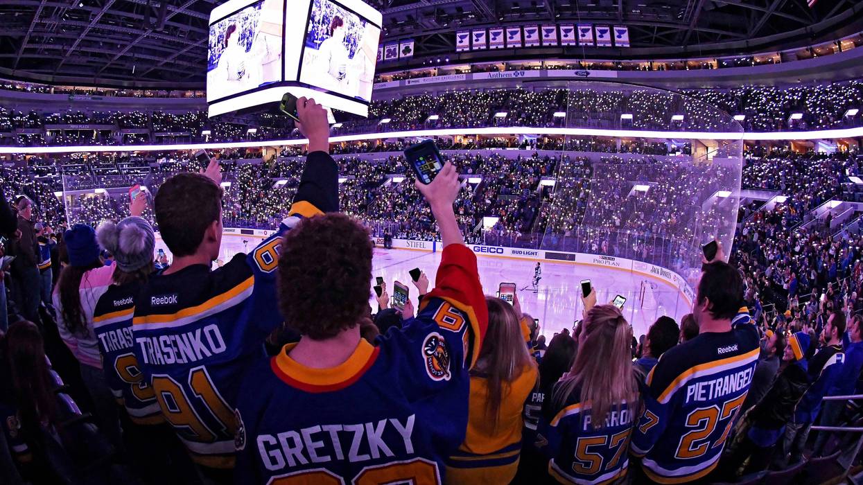 Fans turn on hold up their cell phone flash lights during Hockey Fights Cancer ceremony