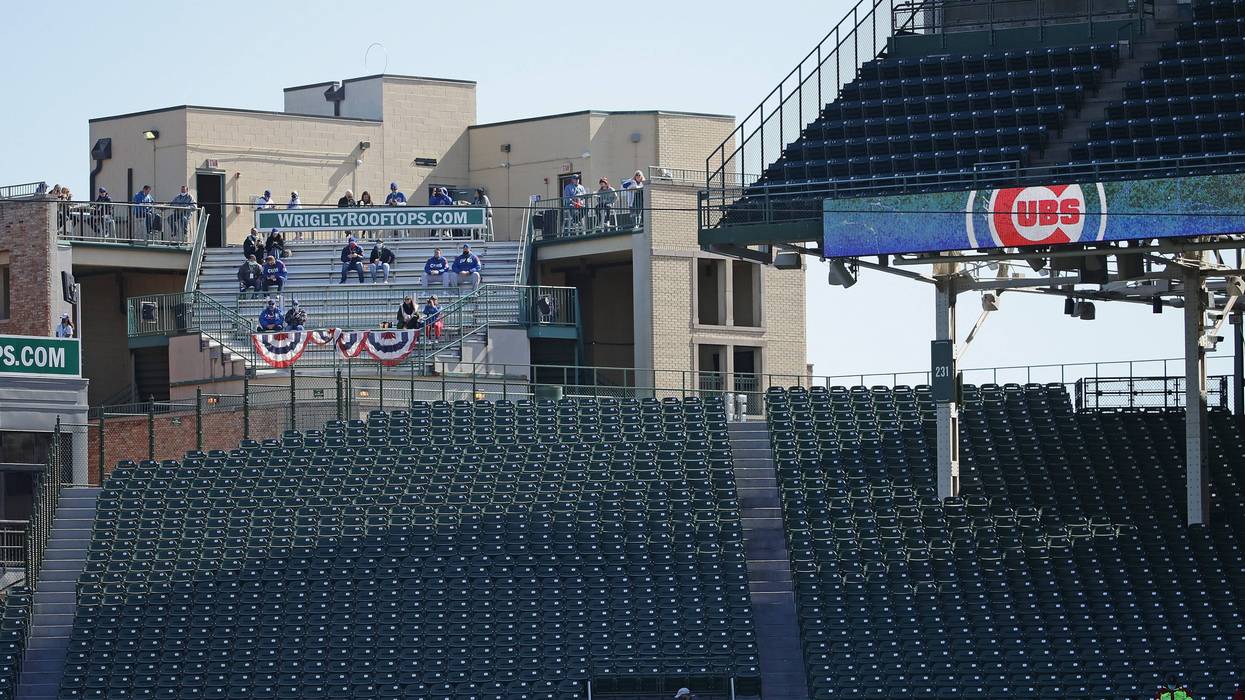 Fans watch from a rooftop as the Chicago Cubs take on the Miami Marlins during Game Two of the National League Wild Card Series at Wrigley Field on October 02, 2020 in Chicago, Illinois.