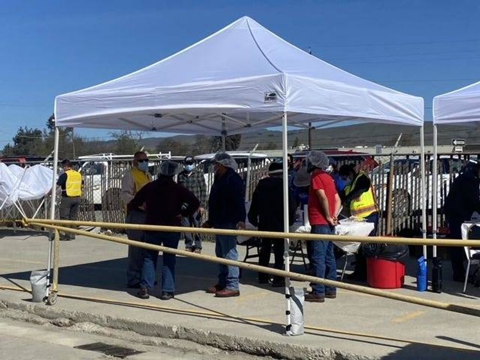 Farmworkers await a vaccine on Sunday.