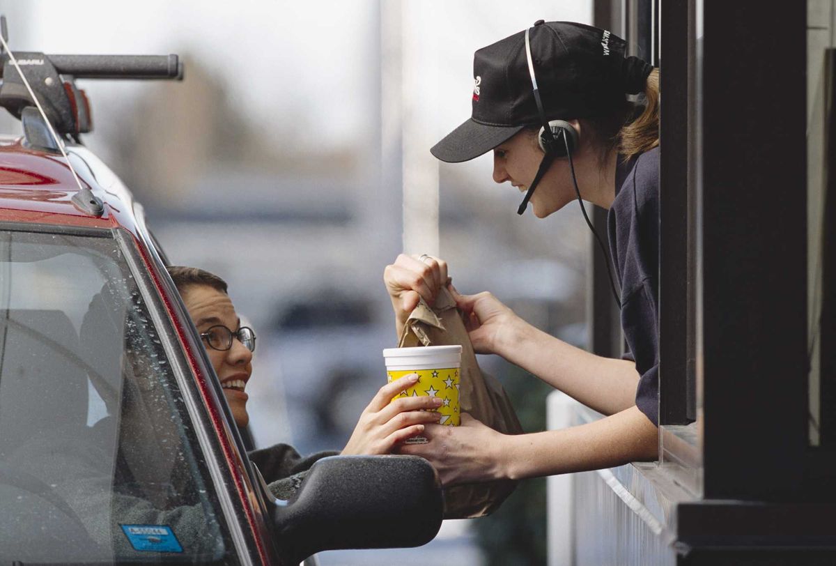 Fast food worker giving a customer their food.