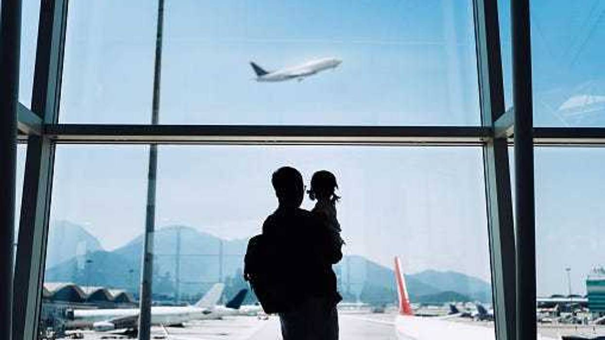 Father and daughter watching a plane take off while awaiting departure