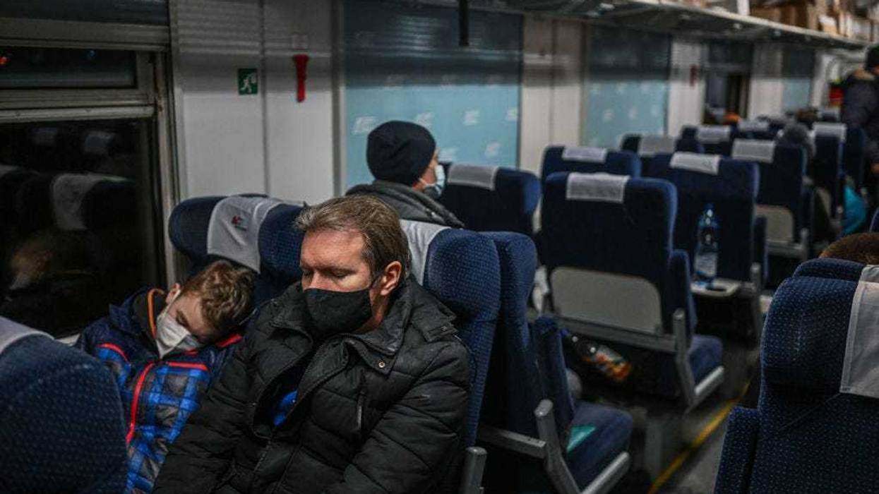 Father and son sleep as others receive medical assistance inside a train wagon transformed for medical transport on March 03, 2022 in Przemysl, Poland. Around a dozen children with chronic illnesses who were being treated in a Kharkiv hospital were transported by train from Mosciska, Ukraine to Poland today. They are among the hundreds of thousands of people who have fled Ukraine into Poland as Russia continues its invasion of Ukraine. (Photo by Omar Marques/Getty Images)