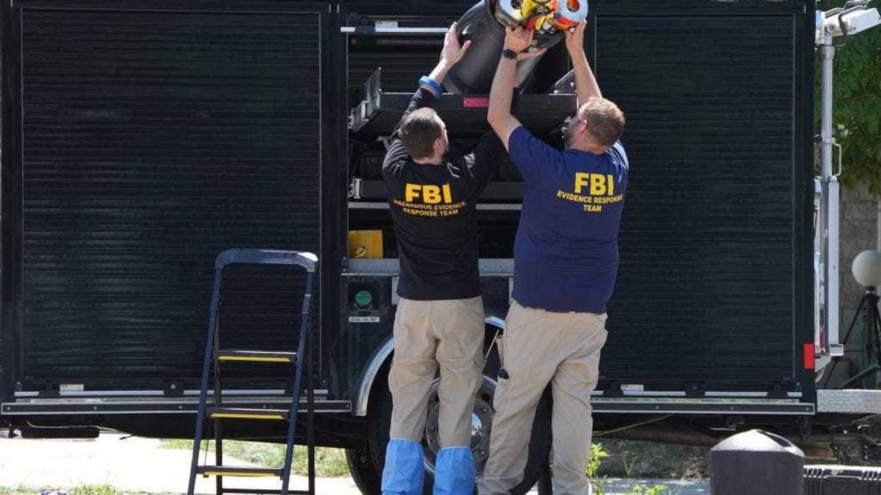 FBI officials unload the equipment as they process the home of Craig Robertson who was shot and killed by the FBI in a raid on his home this morning on August 9, 2023 in Provo, Utah. The FBI was investigating alleged threats by Robertson to President Biden who is visiting Salt Lake City today and tomorrow. (Photo by George Frey/Getty Images)