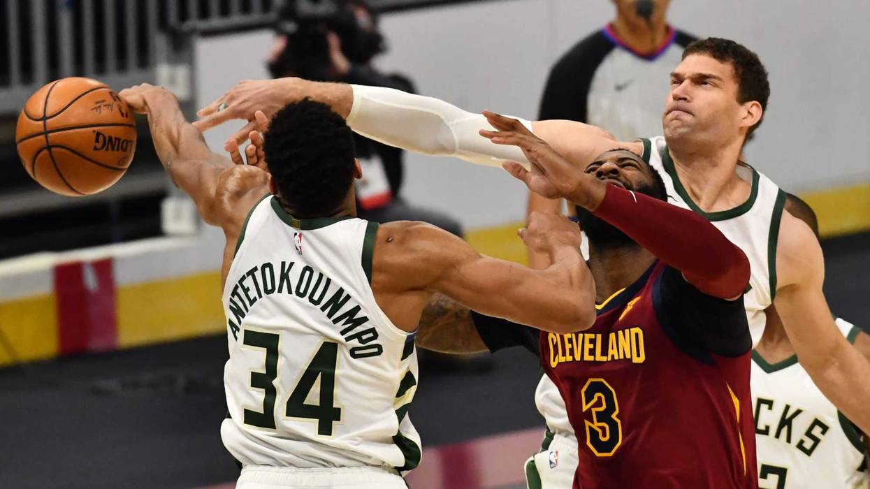 Feb 5, 2021; Cleveland, Ohio, USA; Milwaukee Bucks center Brook Lopez (11) and forward Giannis Antetokounmpo (34) knock the ball away from Cleveland Cavaliers center Andre Drummond (3) during the second quarter at Rocket Mortgage FieldHouse.