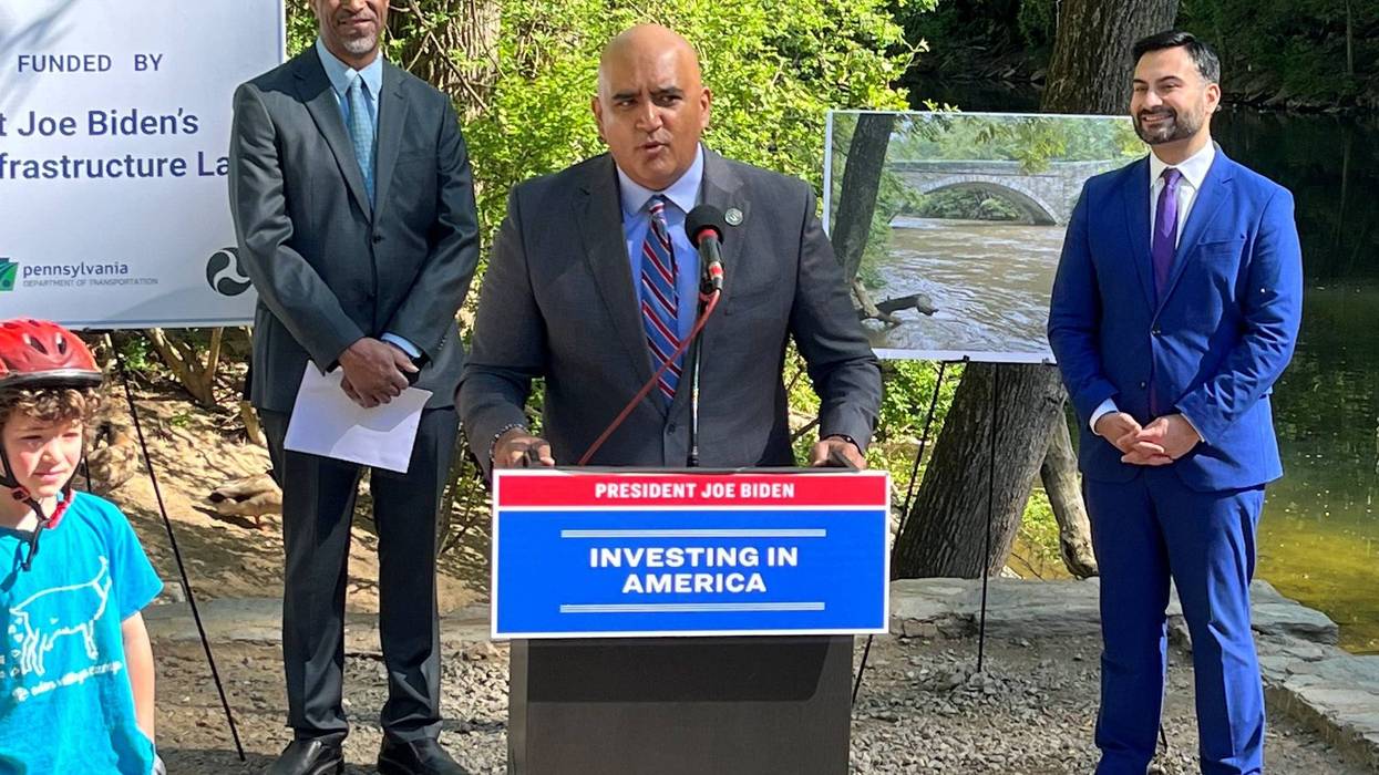 Federal Highway Administrator Shailen Bhatt (center) announces a $14.2 million federal grant to repair the historic Bells Mill Road and Valley Green Road bridges, along with Office of Transportation and Infrastructure Systems Managing Director Mike Carroll (left) and National Climate Advisor Ali Zaldi (right).