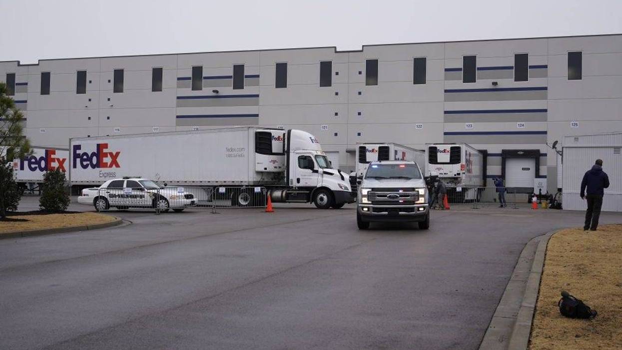 FedEx trucks prepare to move boxes containing the Moderna COVID-19 vaccine