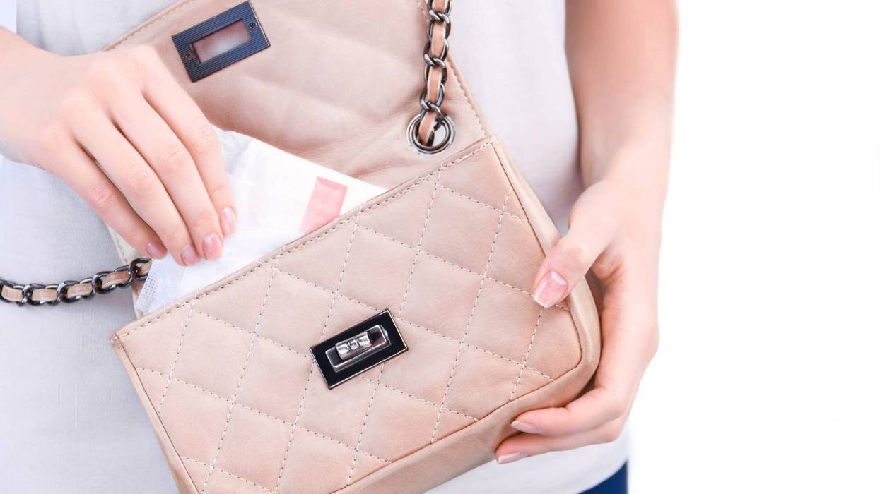 female hand is taking out of bag sanitary pad