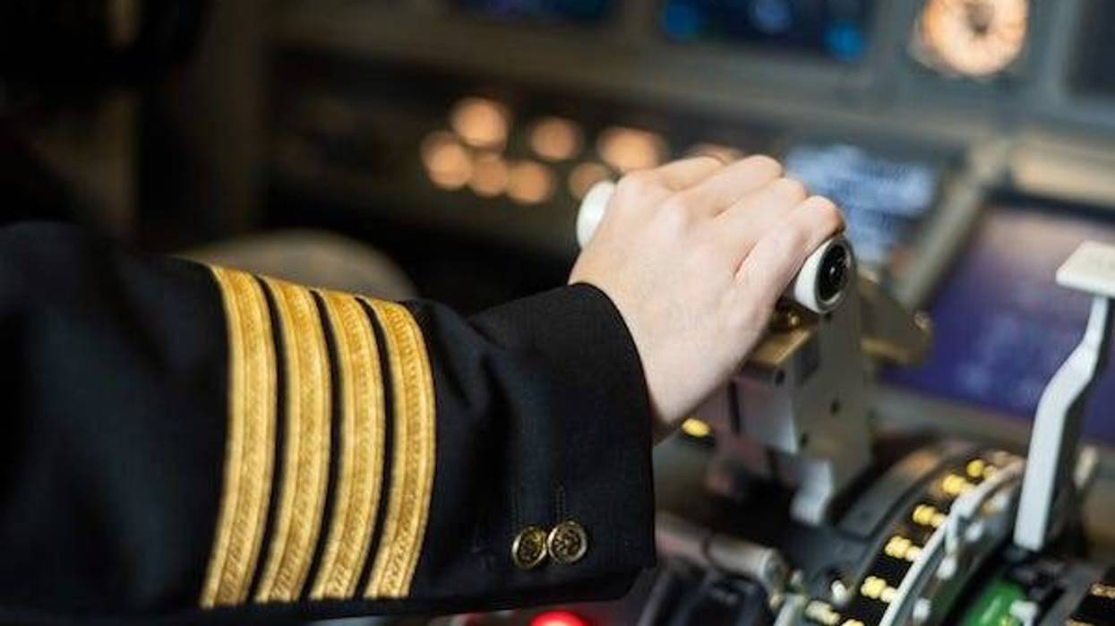Female pilot's hand on the plane engine control stick