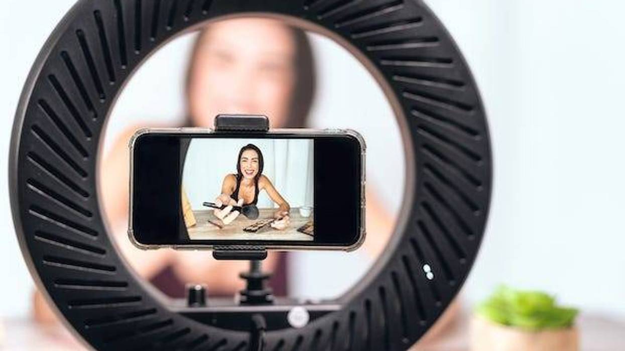 Female vlogger filming makeup tutorial
