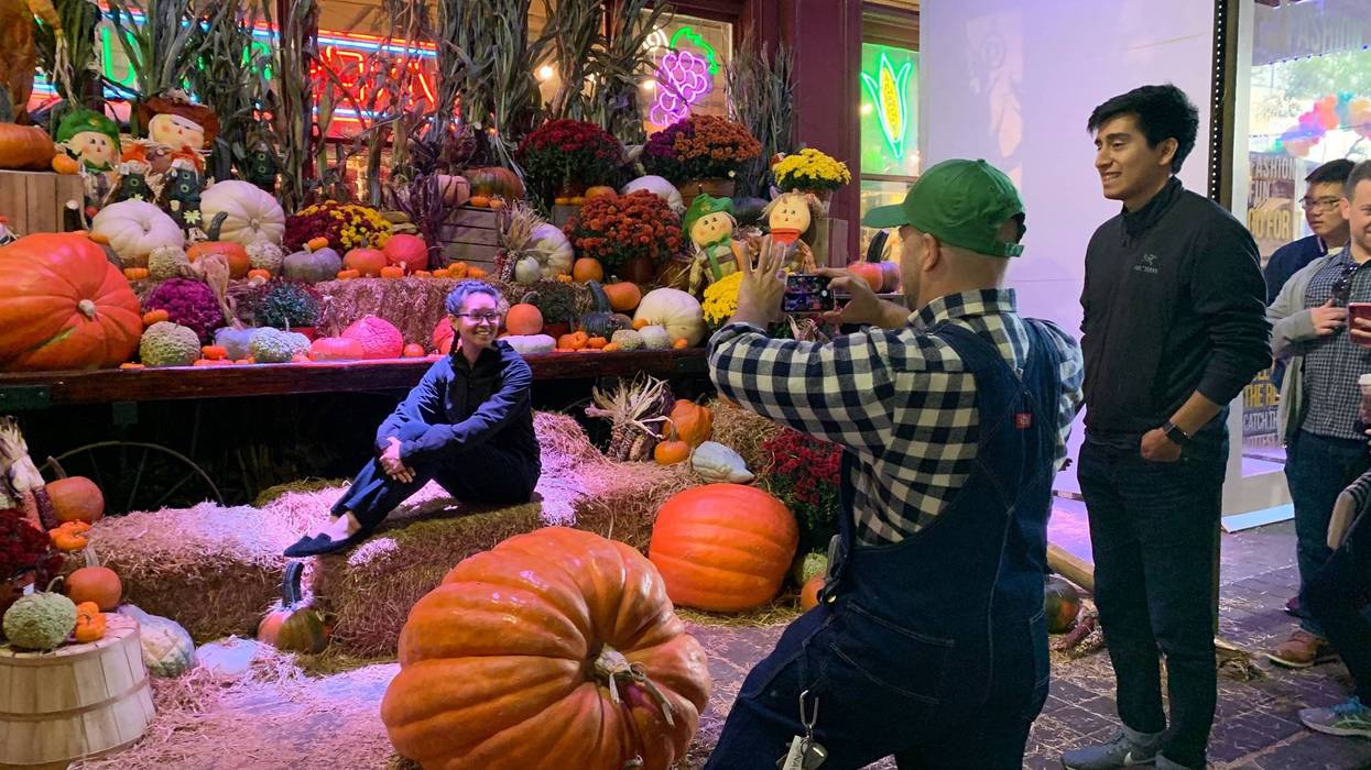 Festival-goers taking pictures with a variety of giant pumpkins and plants at the Reading Terminal Market Harvest Festival.