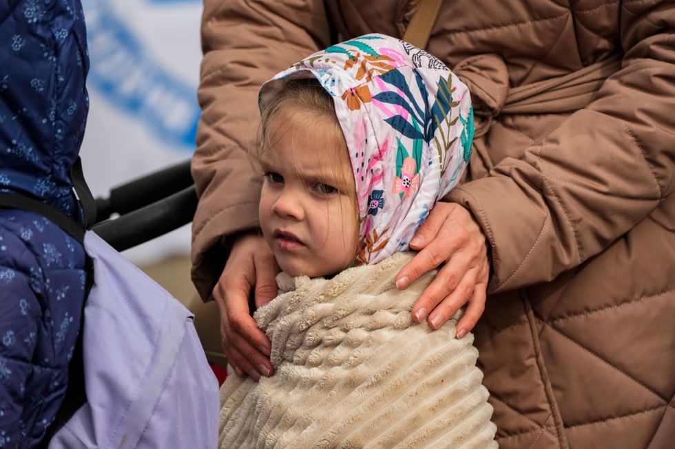 FILE - A refugee child waits in a line after fleeing the war from neighboring Ukraine at the border crossing in Medyka, southeastern Poland, Sunday, April 10, 2022.