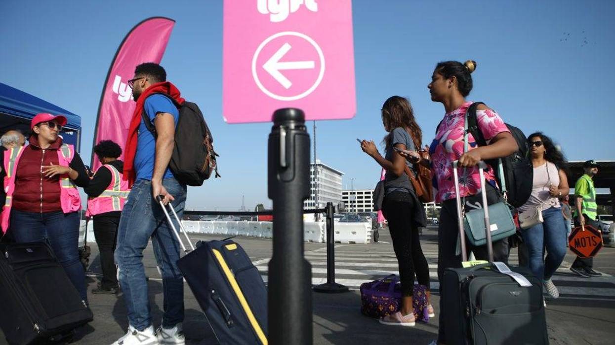 FILE - Arriving passengers wait to board Lyft vehicles at the new 'LAX-it' ride-hail passenger pickup lot at Los Angeles International Airport (LAX) on November 6, 2019 in Los Angeles.