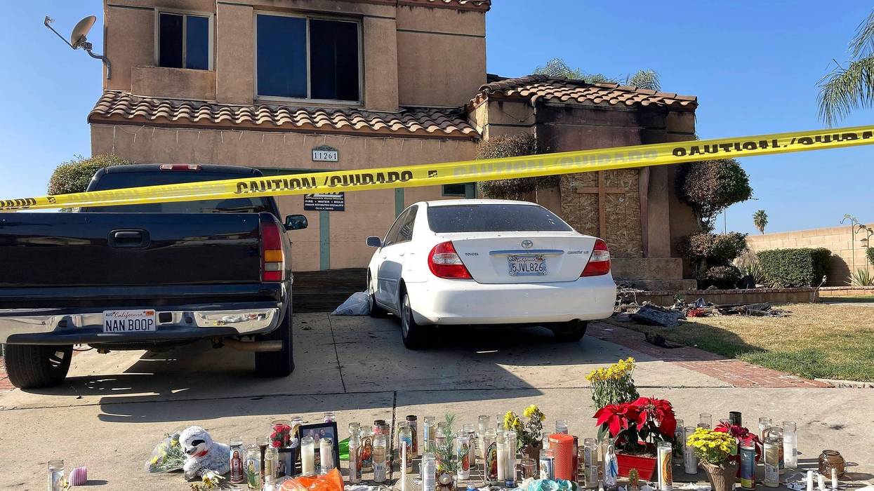 FILE - Dozens of candles sit placed on the sidewalk along with bouquets of flowers and stuffed animals outside a charred home in Riverside, Calif., on Nov. 30, 2022. The Virginia Office of the State Inspector General is investigating the state police hiring of a man who drove across the country, kidnapped a 15-year-old California girl and killed her mother and grandparents.