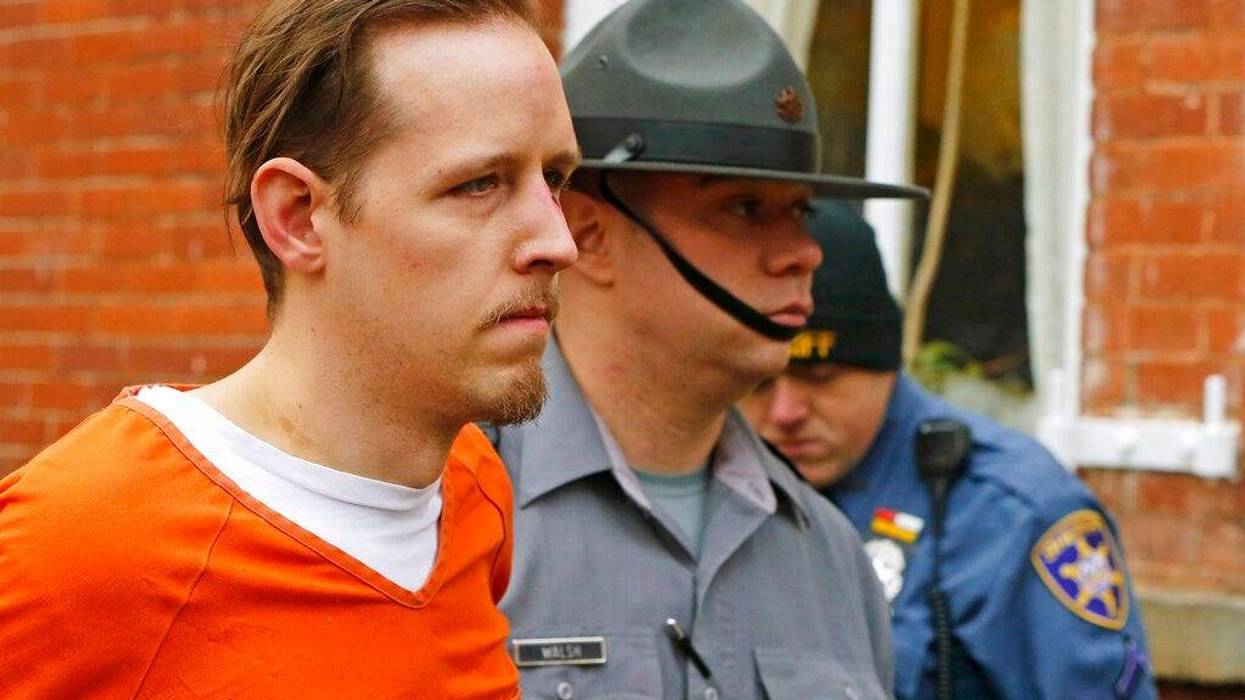 FILE – Eric Frein, left, is escorted out by police after his arraignment at the Pike County Courthouse on Oct. 31, 2014, in Milford, Pa. The parents of Frein, a gunman who killed a Pennsylvania state trooper and permanently disabled another eight years ago in an ambush of a police barracks have settled a lawsuit that accused them of partial responsibility for the attack. A Lackawanna County judge was to hear arguments on the motion Oct. 31, 2022, but court documents indicate that he was advised that the case had been settled, the Wilkes-Barre Citizens' Voice reported.