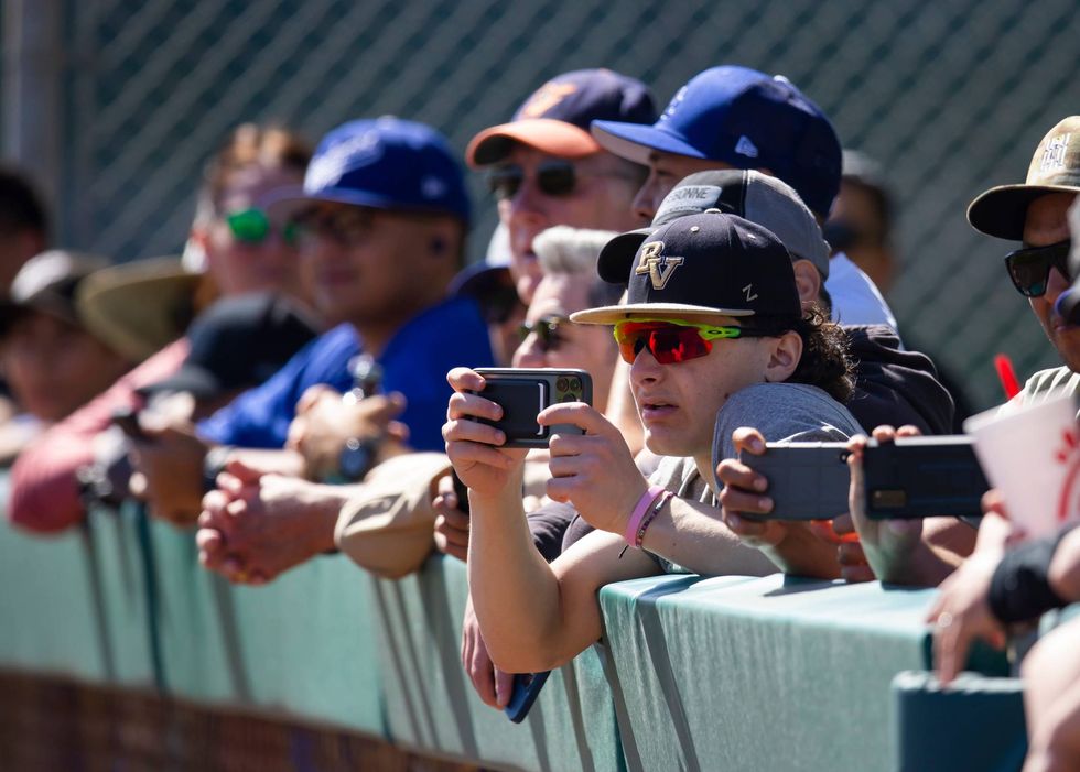 FILE - Fans look on during Los Angeles Dodgers spring training workouts on Mar 14, 2022 at Camelback Ranch in Glendale, Ariz.
