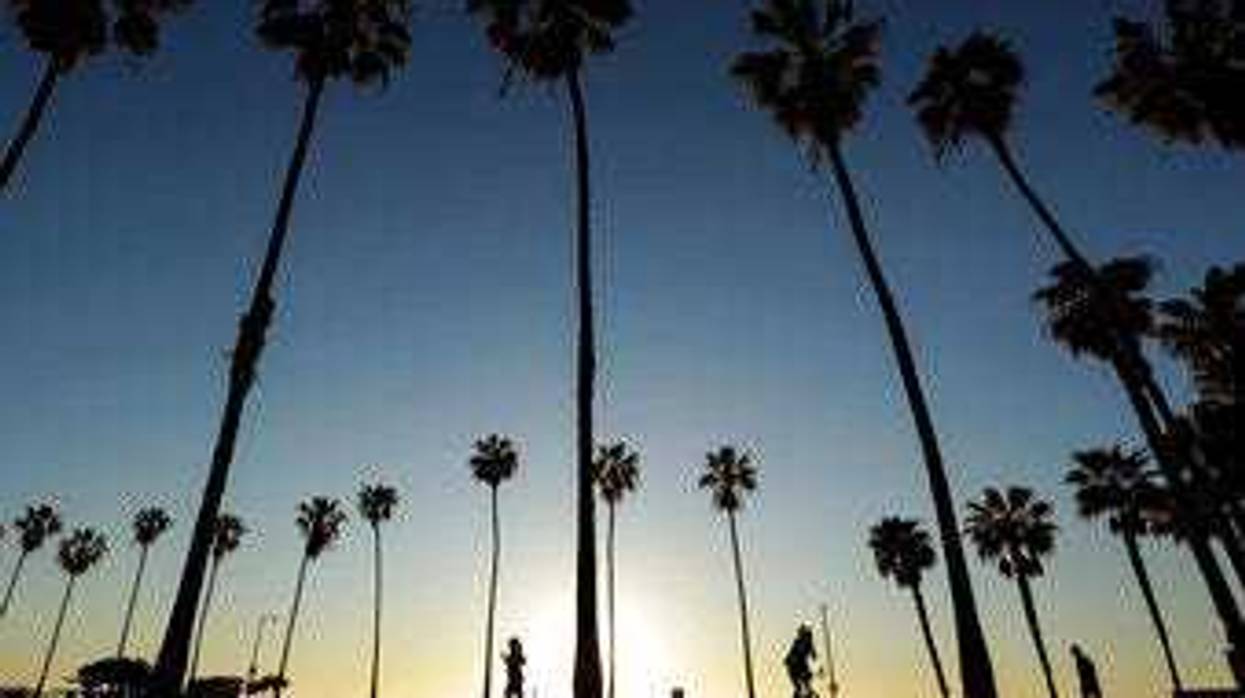 FILE - In this April 15, 2020, file photo, people keep their distance as they exercise outside of a closed La Jolla beach in San Diego. (AP Photo/Gregory Bull, File)