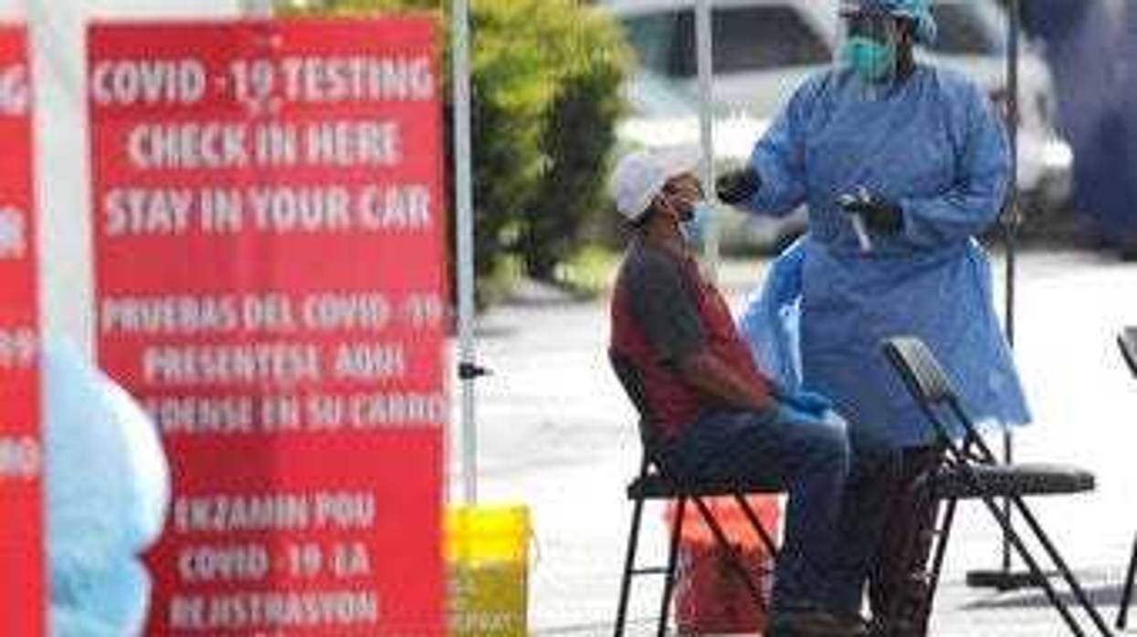 FILE - In this July 6, 2020 file photo, a health care worker administers a COVID-19 test at a site sponsored by Community Heath of South Florida at the Martin Luther King, Jr. Clinica Campesina Health Center in Homestead, Fla.(AP Photo/Lynne Sladky, File)