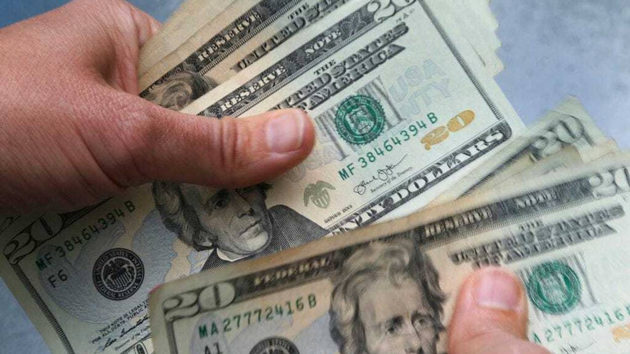 FILE - In this June 15, 2018, file photo, 20-dollar bills are counted in North Andover, Mass.