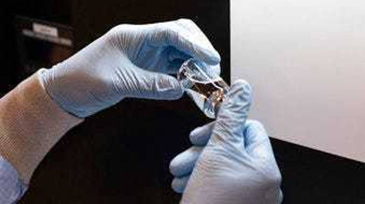 FILE - In this March 2020 photo provided by Gilead Sciences, a vial of the investigational drug remdesivir is visually inspected at a Gilead manufacturing site in the United States. (Gilead Sciences via AP)