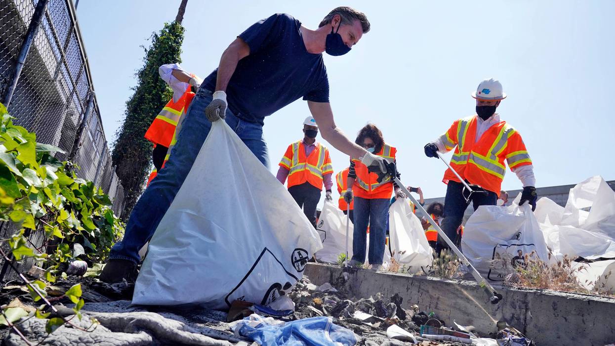 FILE - In this May 11, 2021, file photo, California Gov. Gavin Newsom joins a cleanup effort in Los Angeles. Newsom on Wednesday, July 7, 2021, launched a $1.1 billion plan to clean trash and graffiti from California's highways, roads and other public spaces, in an effort he said will beautify the state and create 11,000 jobs.