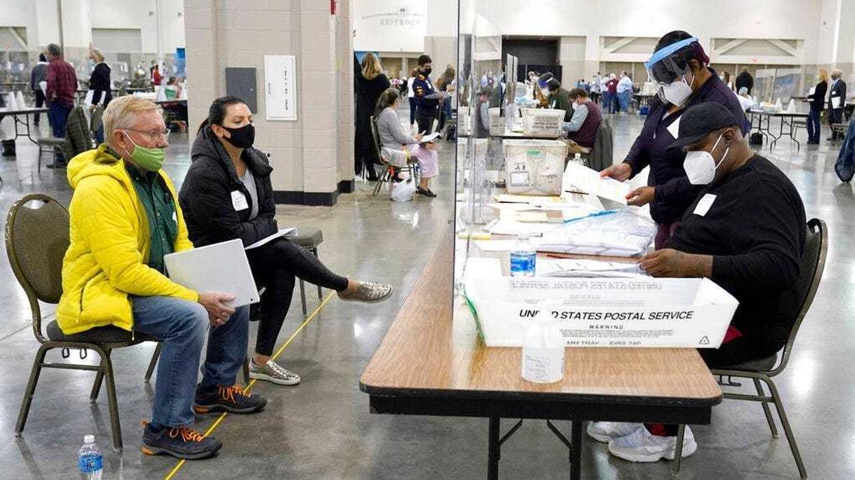 FILE - In this Nov. 20, 2020, file photo, election workers, right, verify ballots as recount observers, left, watch during a Milwaukee hand recount of presidential votes at the Wisconsin Center in Milwaukee. (AP Photo/Nam Y. Huh File)